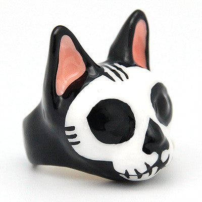 Handcrafted cat skull earrings with black and white design and pink accents.