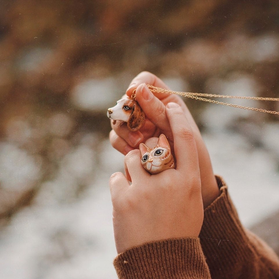 Close-up of cat ring and and dog necklace in hands