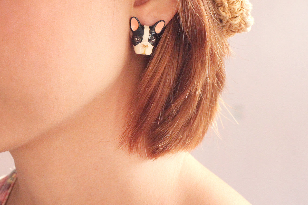 Handmade French Bulldog earrings displayed on a model.