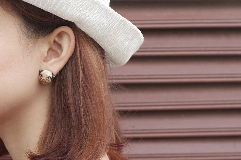 Close-up of a person wearing a pug earring, perfect for dog lovers.