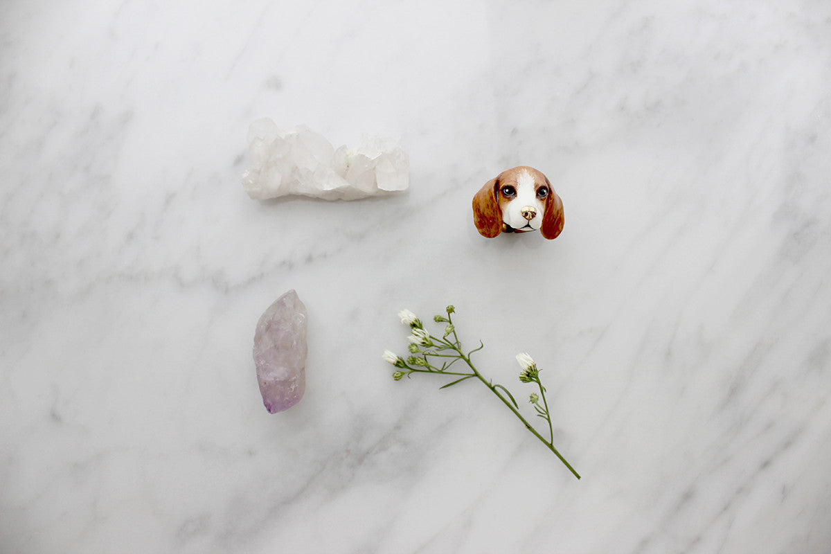 Charming dog ring displayed with beautiful crystals and greener on marble background