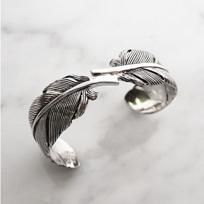 Stylish silver bangle with detailed feather patterns