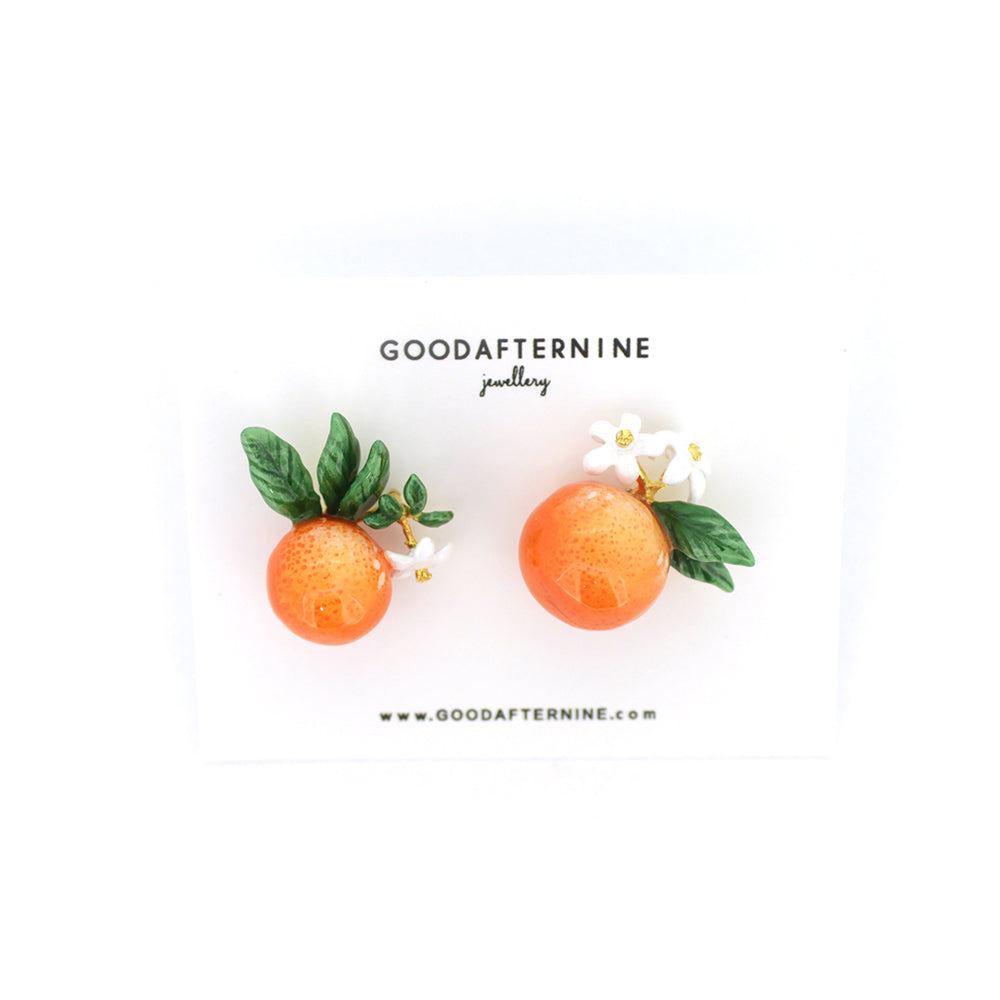 Beautiful orange earrings adorned with delicate white flowers and green leaves, ideal for summer fashion.