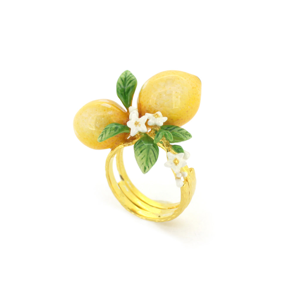 A charming gold ring featuring two yellow lemons, green leaves, and small white flowers, embodying a vibrant, nature-inspired design.