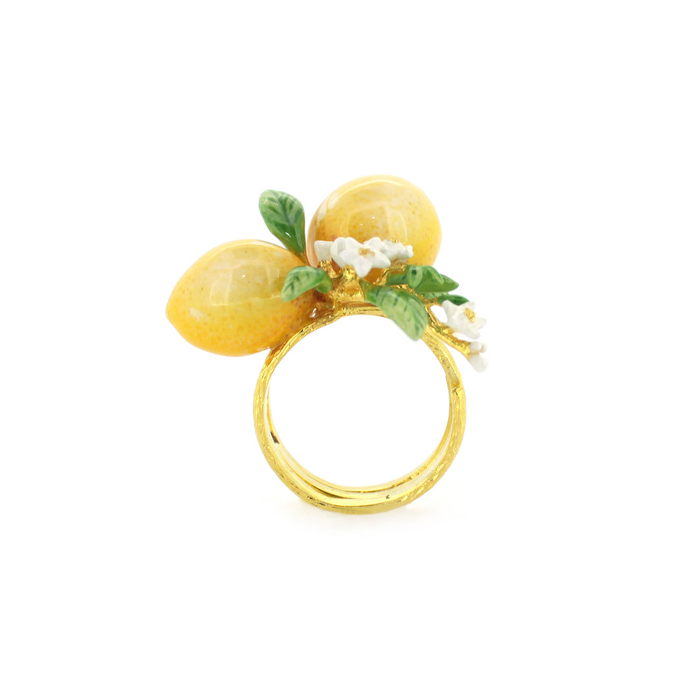 A charming gold ring featuring two yellow lemons, green leaves, and small white flowers, embodying a vibrant, nature-inspired design.