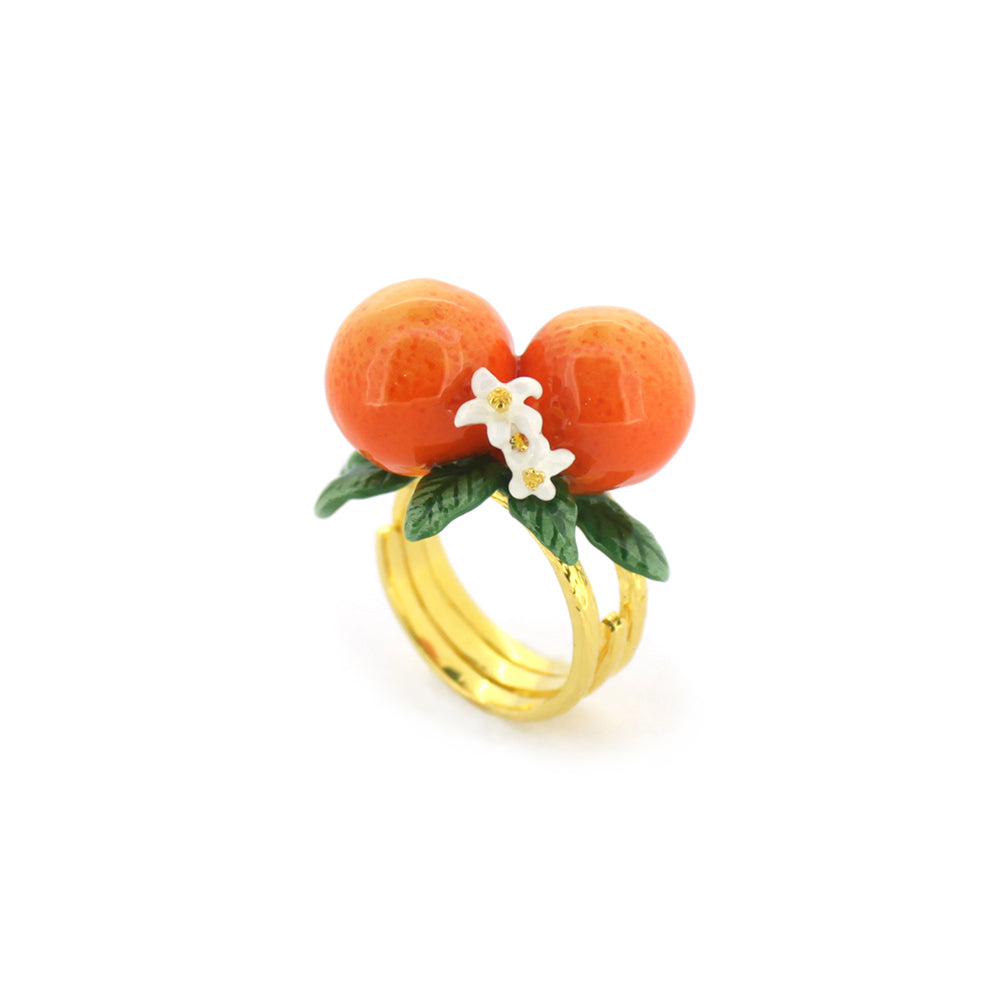 A stunning gold ring featuring two oranges, green leaves, and small white flowers, embodying a vibrant, nature-inspired design.