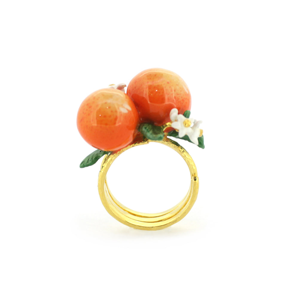 A stunning gold ring featuring two oranges, green leaves, and small white flowers, embodying a vibrant, nature-inspired design.