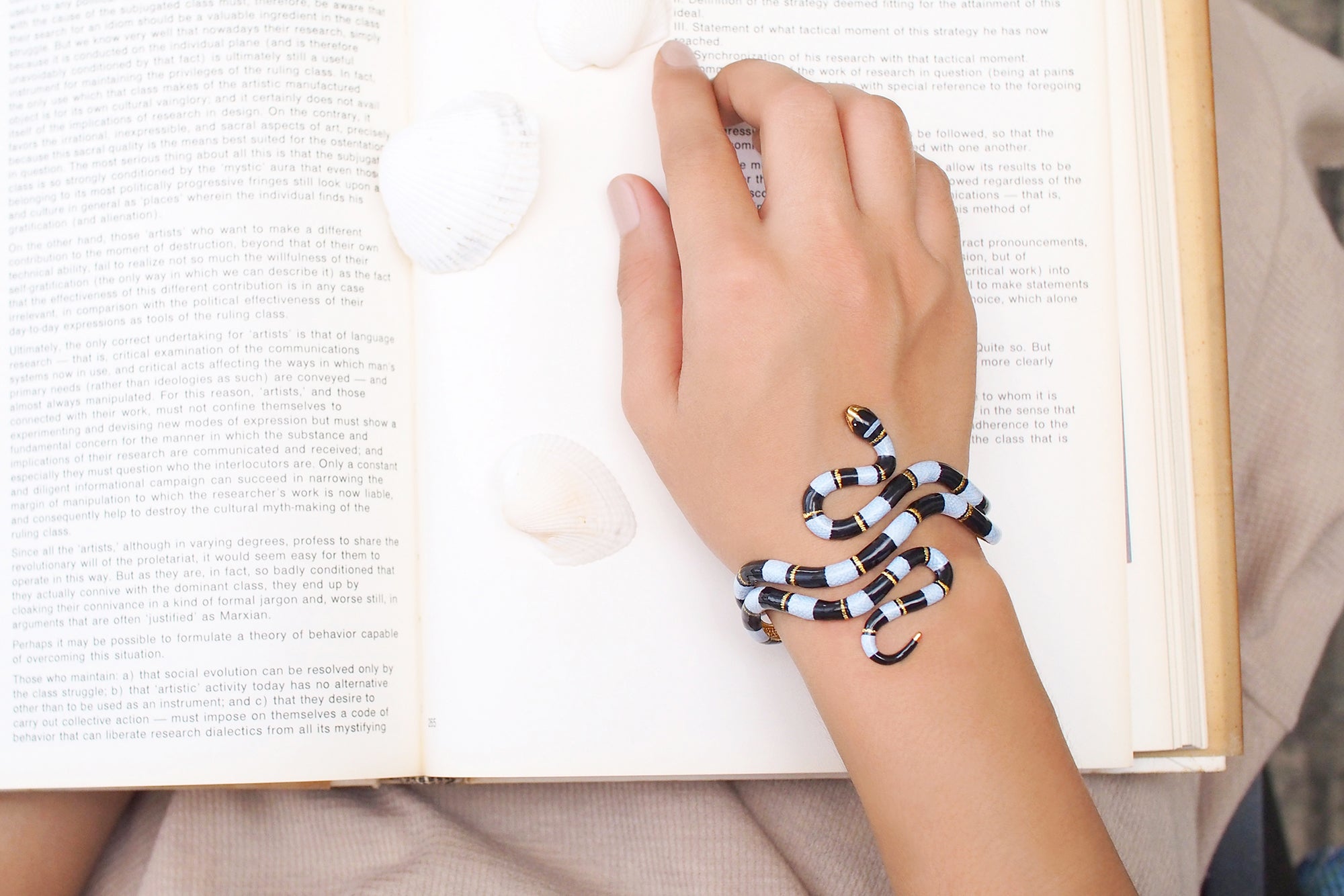 A striking blue sea snake bangle elegantly around a model's wrist.