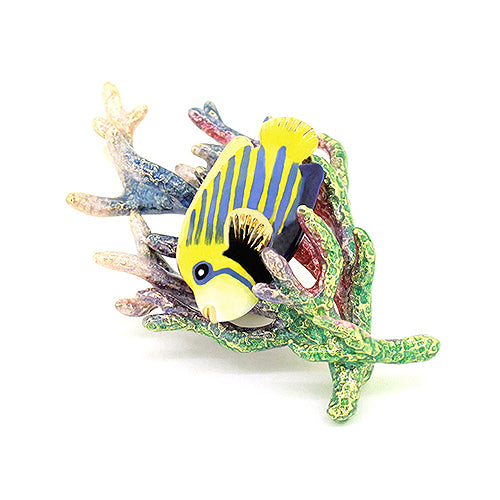 An enamel fish brooch with yellow and blue stripes, attached to a colorful coral piece.