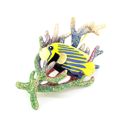 An enamel fish brooch with yellow and blue stripes, attached to a colorful coral piece.