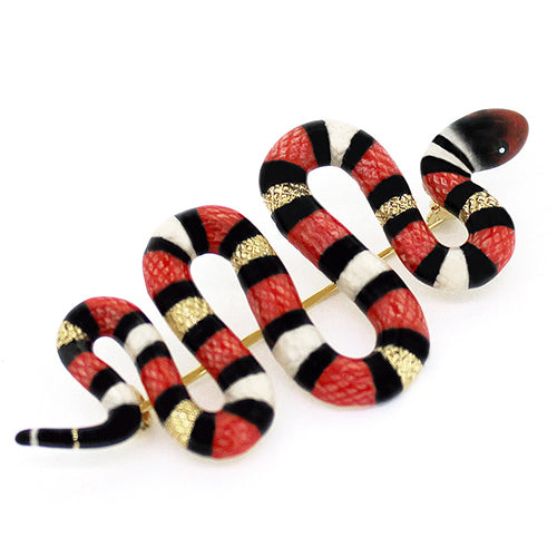 An eye-catching red milk snake brooch, featuring black and white stripes.