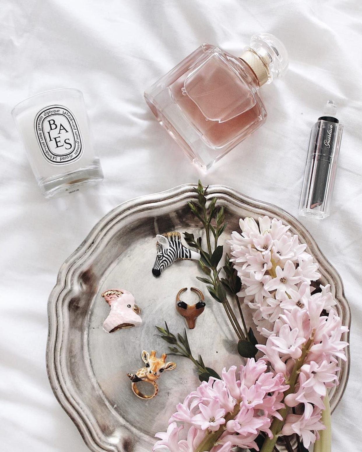 A collection of unique animal-themed rings featuring a giraffe, zebra, bird, and fox on a decorative tray.