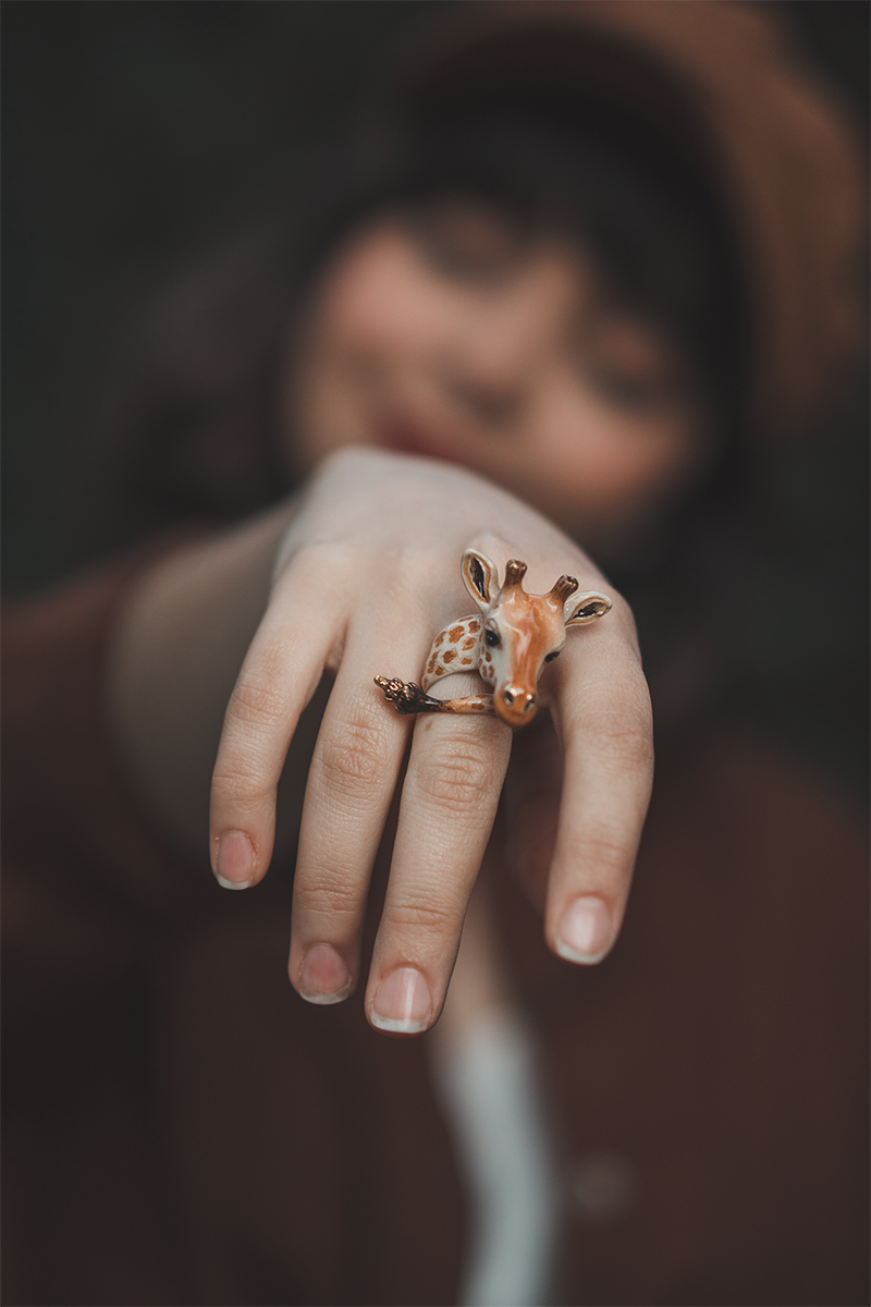 Playful giraffe ring worn by a woman, showcasing unique fashion