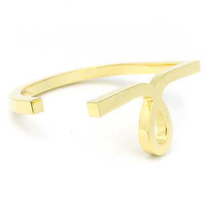 Gold bangle featuring a unique script-style small "L" design.