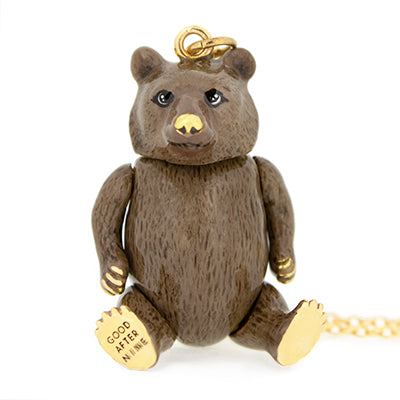 A gold necklace with a bear-shaped pendant that has detailed fur texture and realistic facial features.