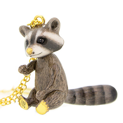 Raccoon pendant on a gold chain, featuring a cute design with intricate details.