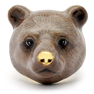 A whimsical ring featuring a grizzly bear face, featuring delicate details and a shiny gold nose.