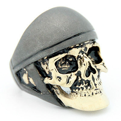 A unique skull ring featuring a realistic skull design topped with a grey helmet.