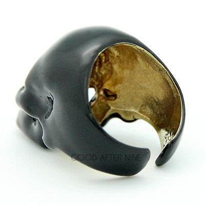 A shiny black skull ring with hollow eye sockets and detailed features.