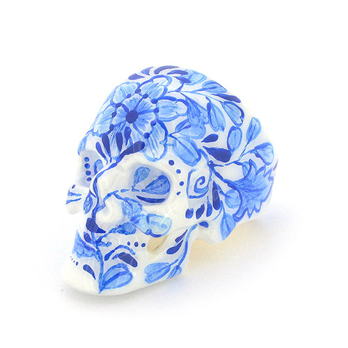 Hand-painted skull ring with artistic blue floral artwork.