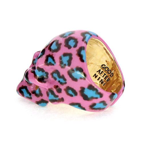 A vibrant skull ring featuring a pink base with a leopard pattern in black and blue, perfect for jewelry lovers.