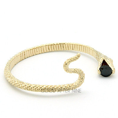 Elegant gold snake bangle with a blue gemstone at its mouth