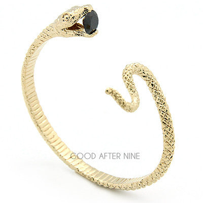 Beautifully crafted gold snake bangle with a blue gemstone at its mouth