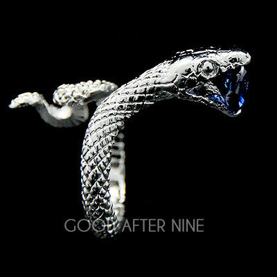 A silver ring featuring snake design, showcasing intricate scales winding around the band, with a blue gemstone in its mouth.