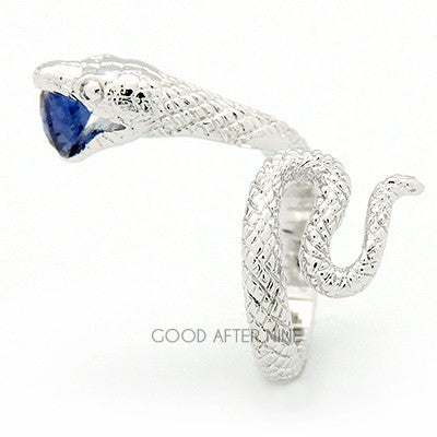 A silver ring featuring snake design, showcasing intricate scales winding around the band, with a blue gemstone in its mouth.