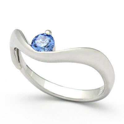 Elegant ring with a blue gemstone set in a wavy band.