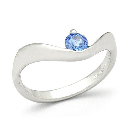 Silver ring with a blue gemstone set in a wavy band.