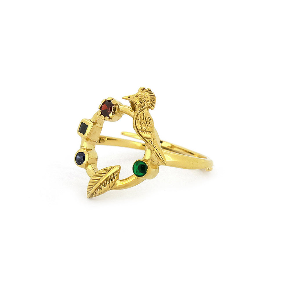 A unique golden ring featuring a bird design and various colored stones.