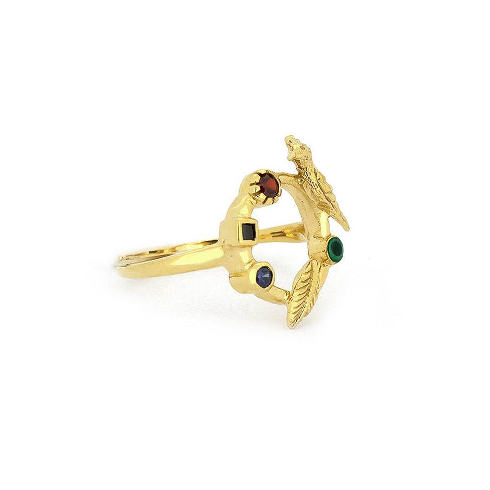 A unique golden ring featuring a bird design and various colored stones.