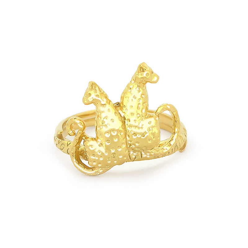 A golden ring featuring two stylized leopards facing each other, adorned with textured detailing and ornate band.