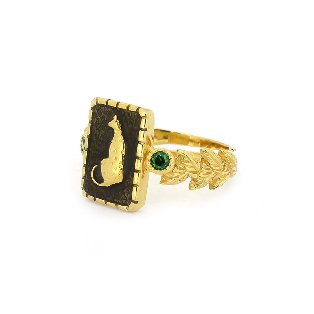 Elegant golden ring featuring a leopard design and green gemstones.