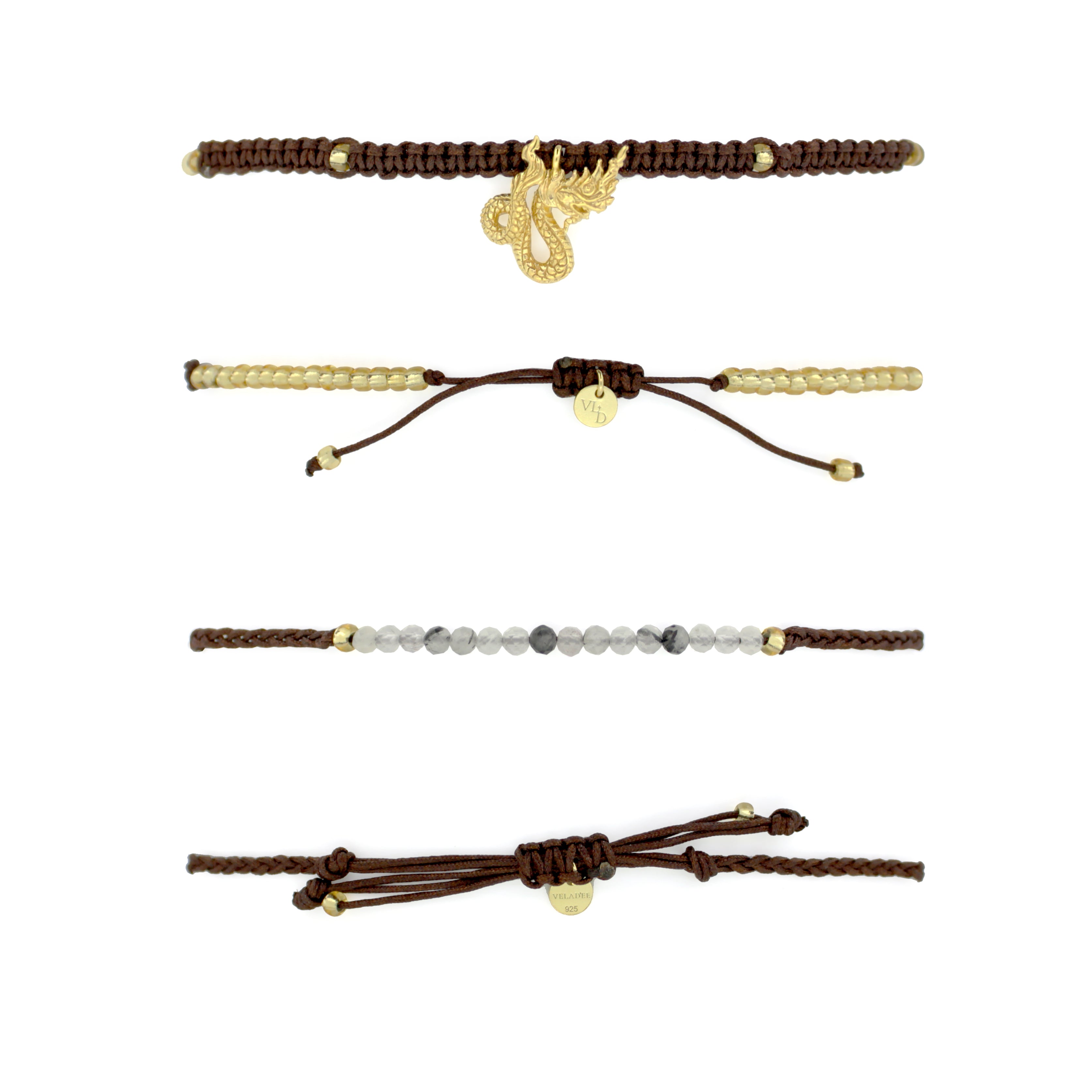 Set of two bracelets the top bracelet featuring a brown woven design material adorned with a gold Naga charm. The bottom bracelet features a series of grey and white beads with a simple woven brown band.