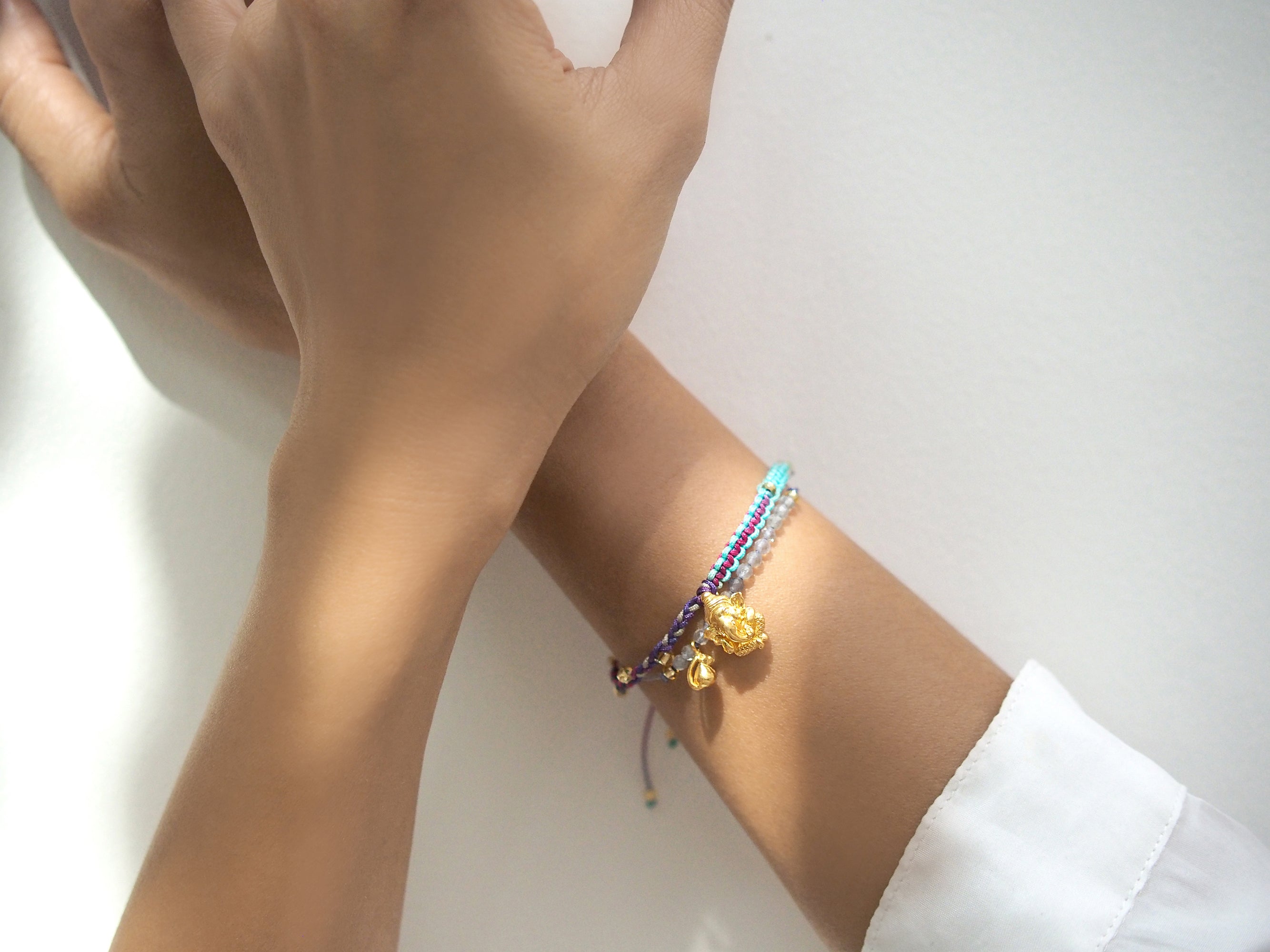 Stylish bracelets set with a Ganesh and Musika charm and beads on model's wrist