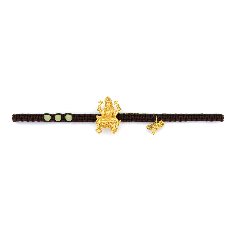 A gold Tridevi Lakshmi charm and a gold owl charm on a brown bracelet with lemon jade stone.