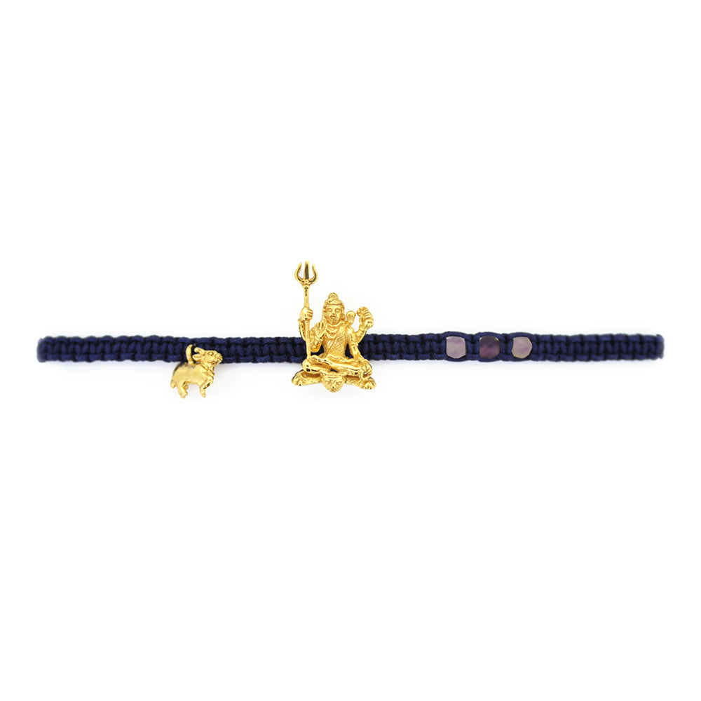 A gold Trimurti Shiva charm and a gold Nandi charm on a royal blue bracelet with amethyst-faced beads.