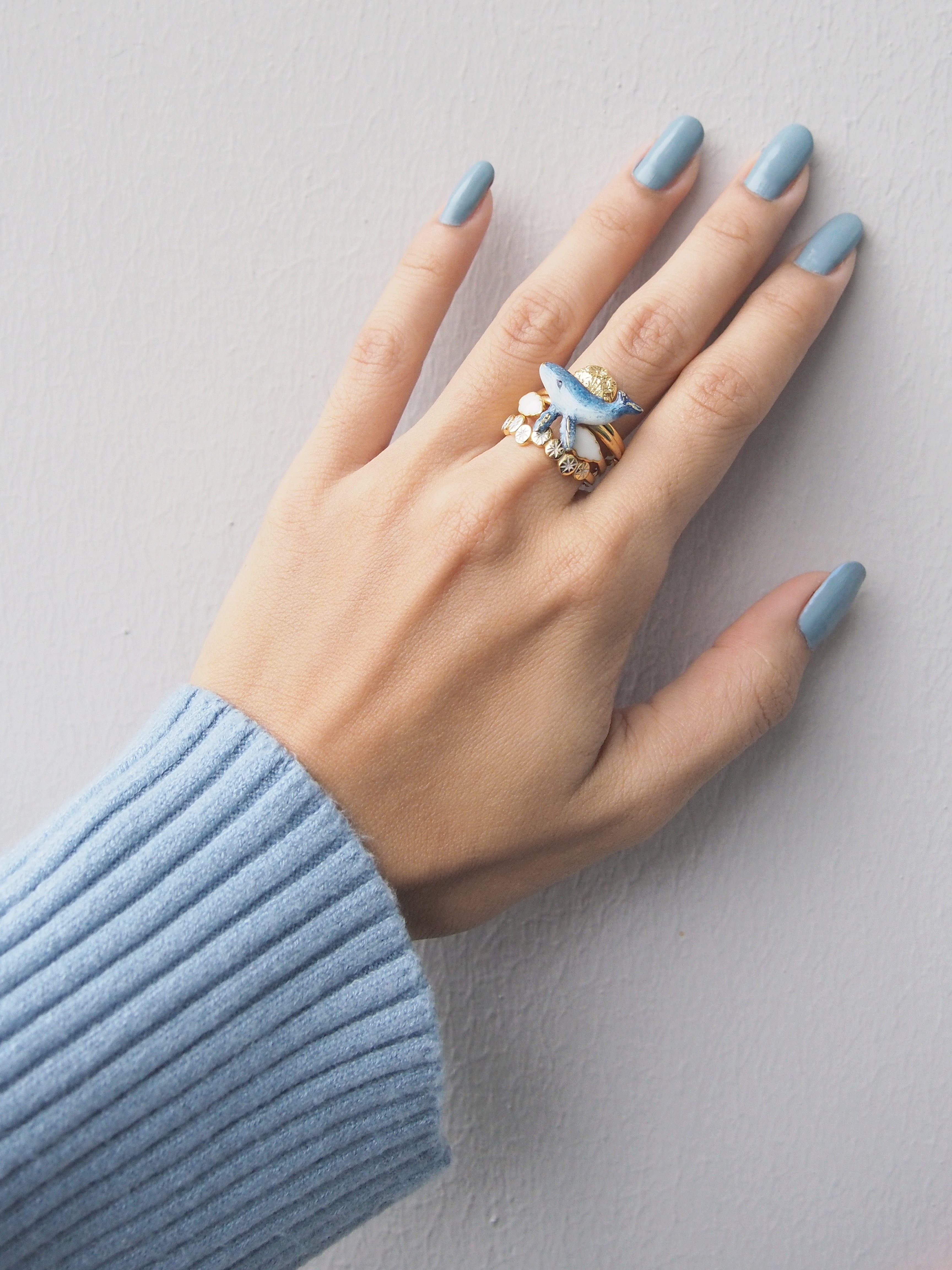 Unique stackable rings including a whale, moon, clouds, and stars, shown on a hand.