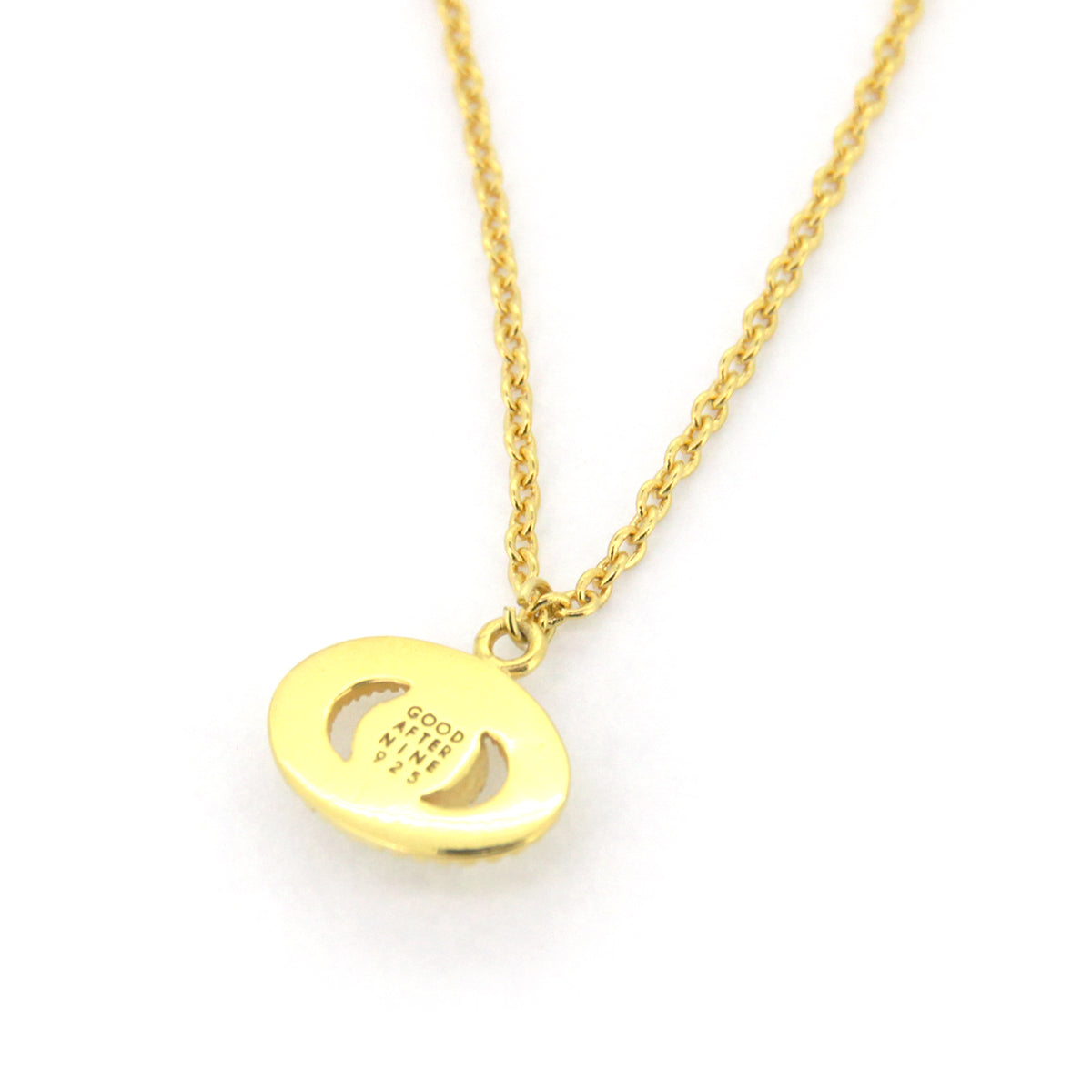 Moon-inspired gold necklace featuring a round pendant with a stone in the center.