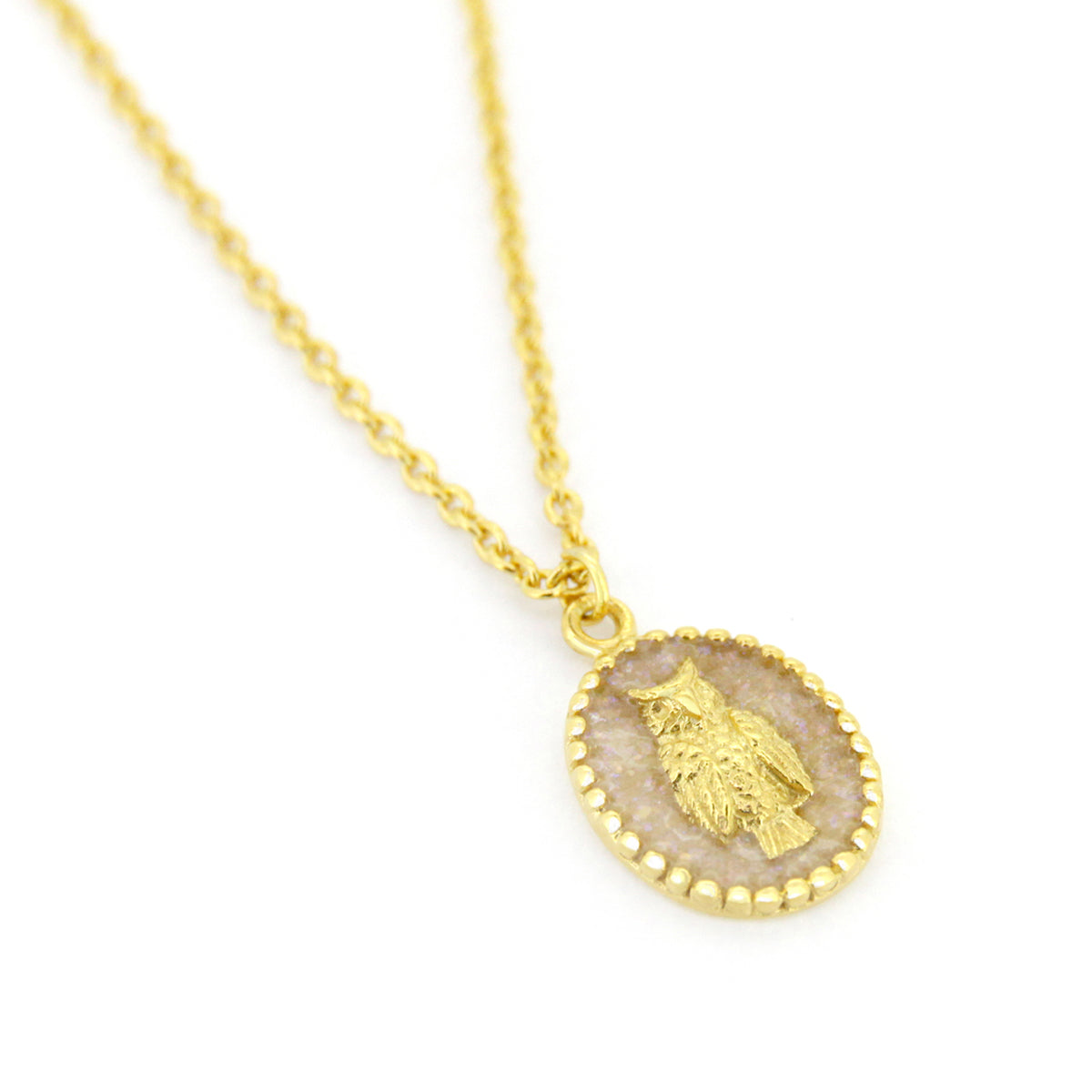 A gold necklace with oval charms showcasing a detailed owl design