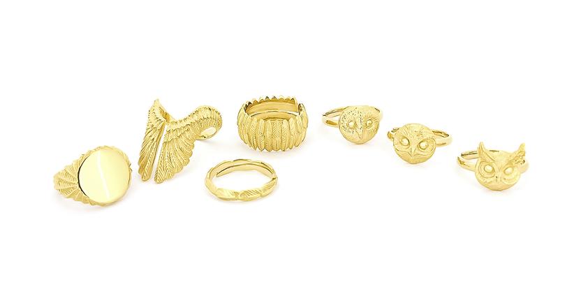 Collection of gold rings featuring owl and feather designs.