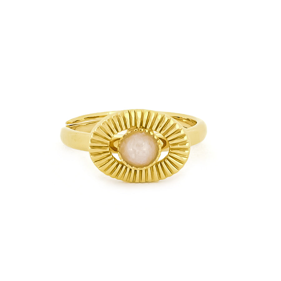 Gold ring with a central stone surrounded by textured rays, inspired by the moon.