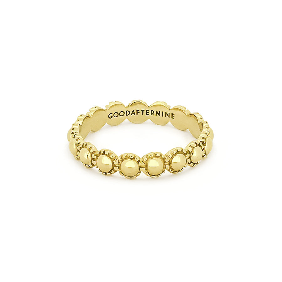 Gold ring featuring a circular, moon-inspired design with textured detailing.