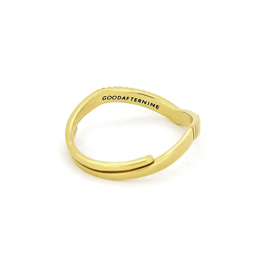 A gold ring features a unique v-shaped silhouette with a texture along its band, inspired by moon beams.