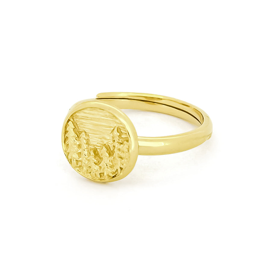 Beautiful gold ring displays an intricately engraved landscape of forest