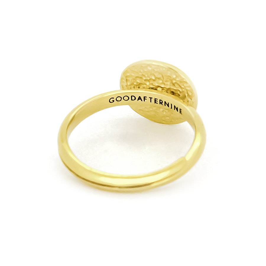 Gold ring with a textured circular top and "GOODAFTERNINE" engraved on the band.