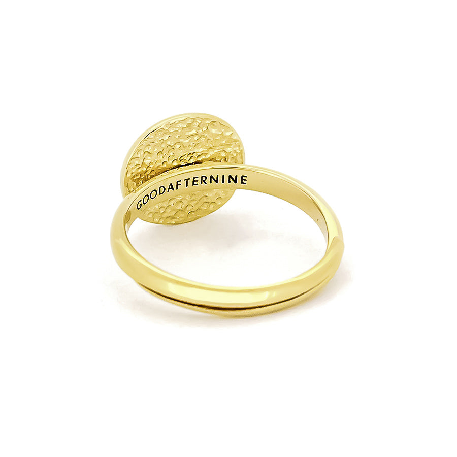 Gold ring with a textured circular top and "GOODAFTERNINE" engraved on the band.