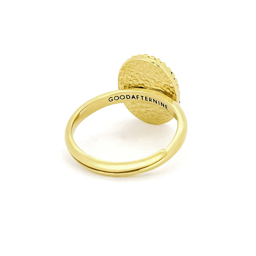 Gold ring with a textured circular top and "GOODAFTERNINE" engraved on the band.